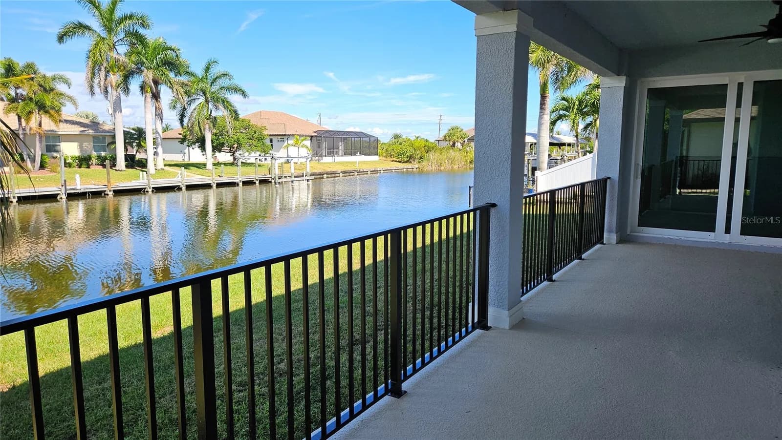 Covered lanai looking down a saltwater canal lined with docks and palms