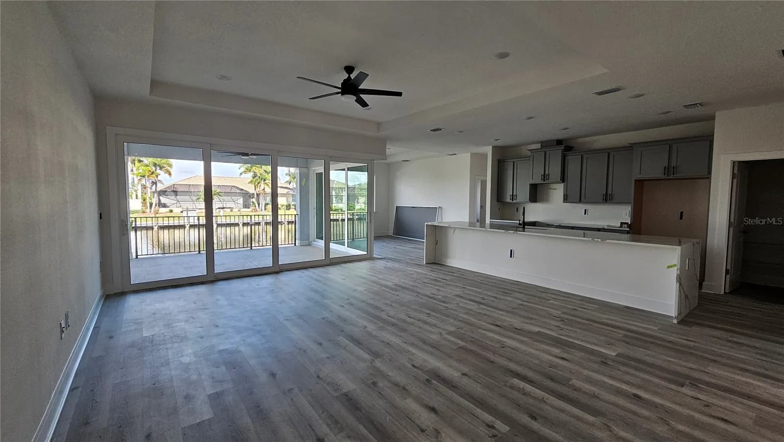 Great room open to the kitchen with sliding doors to the lanai and the canal beyond